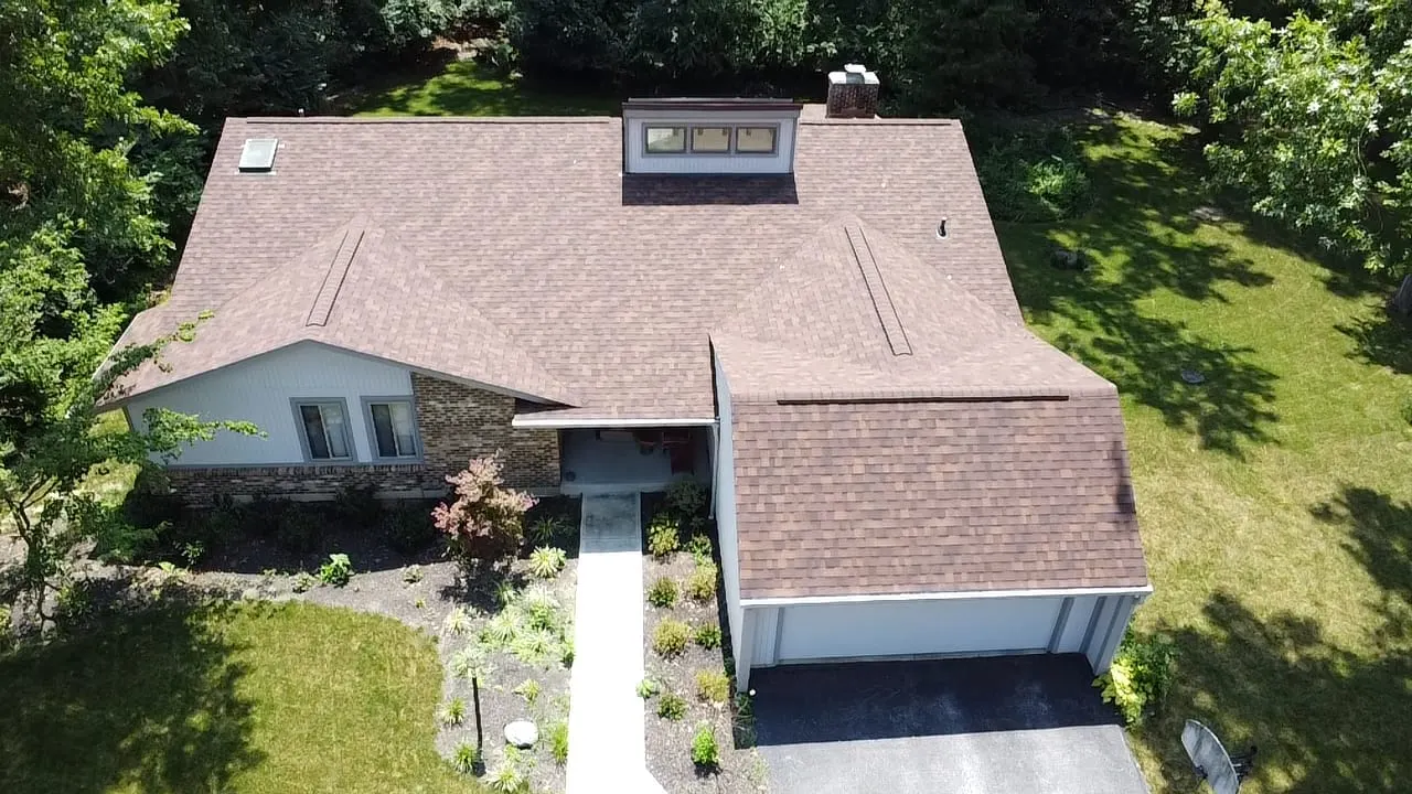 Aerial view of a finished brown shingle roof with skylights
