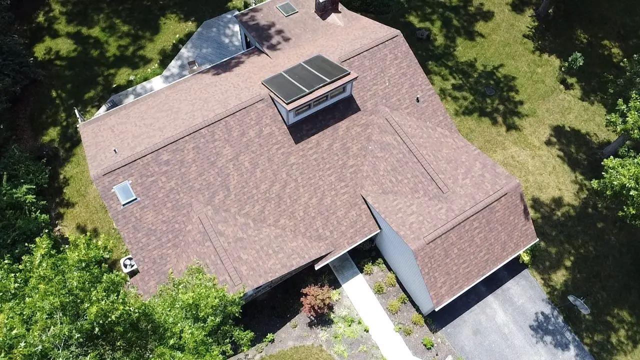 Aerial view of a finished brown roof with skylights from another angle