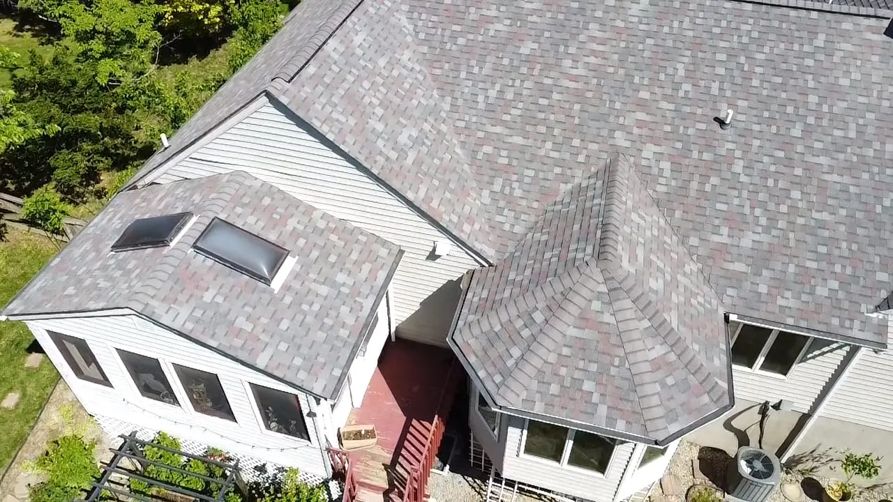 Aerial view of a finished gray shingle roof on a suburban home